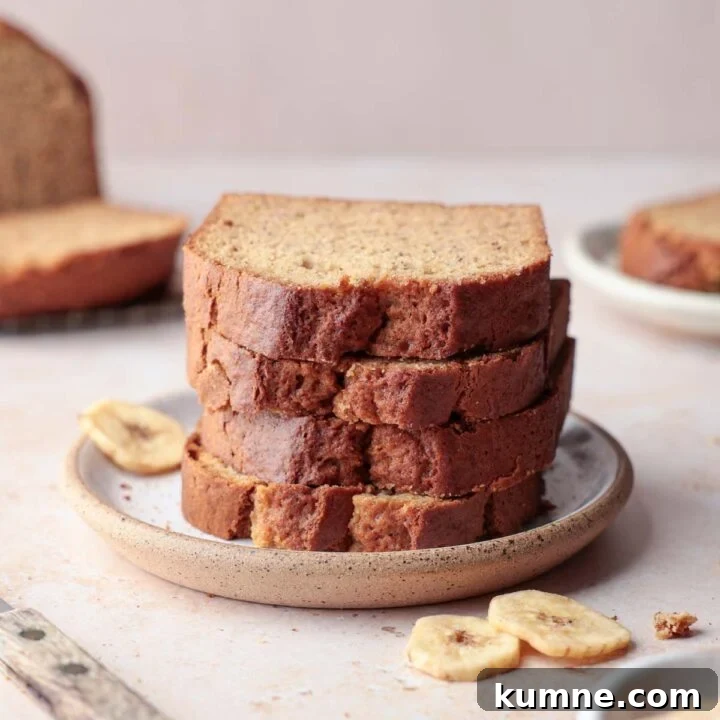 A stack of gluten-free banana bread slices on plate next to banana slices.
