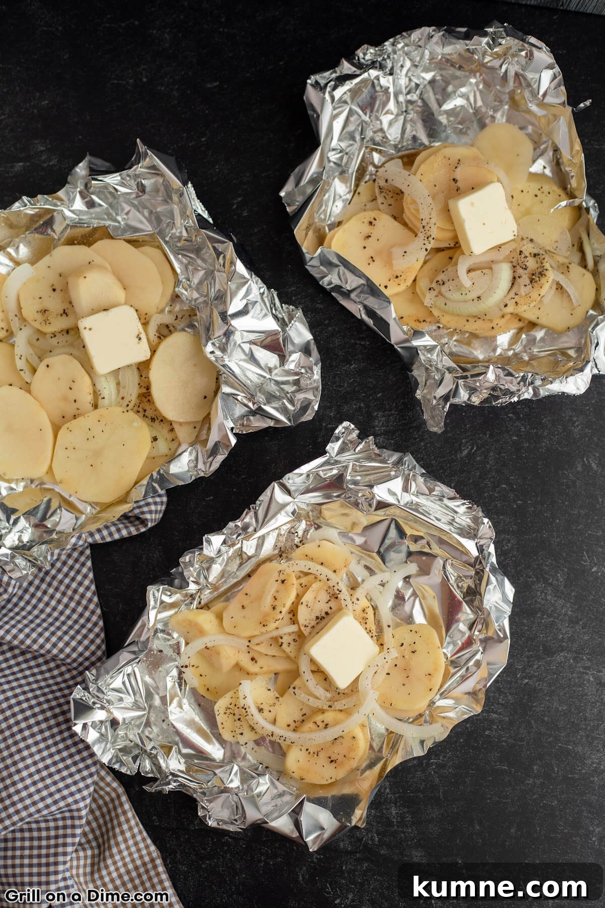 Crispy Foil-Grilled Potatoes with Garlic and Herbs 4 Potatoes in a foil pack topped with butter and onions