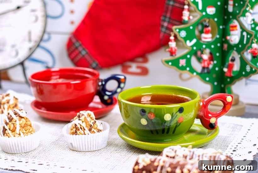 Christmas tea cups next to treats and a decorative Christmas tree.