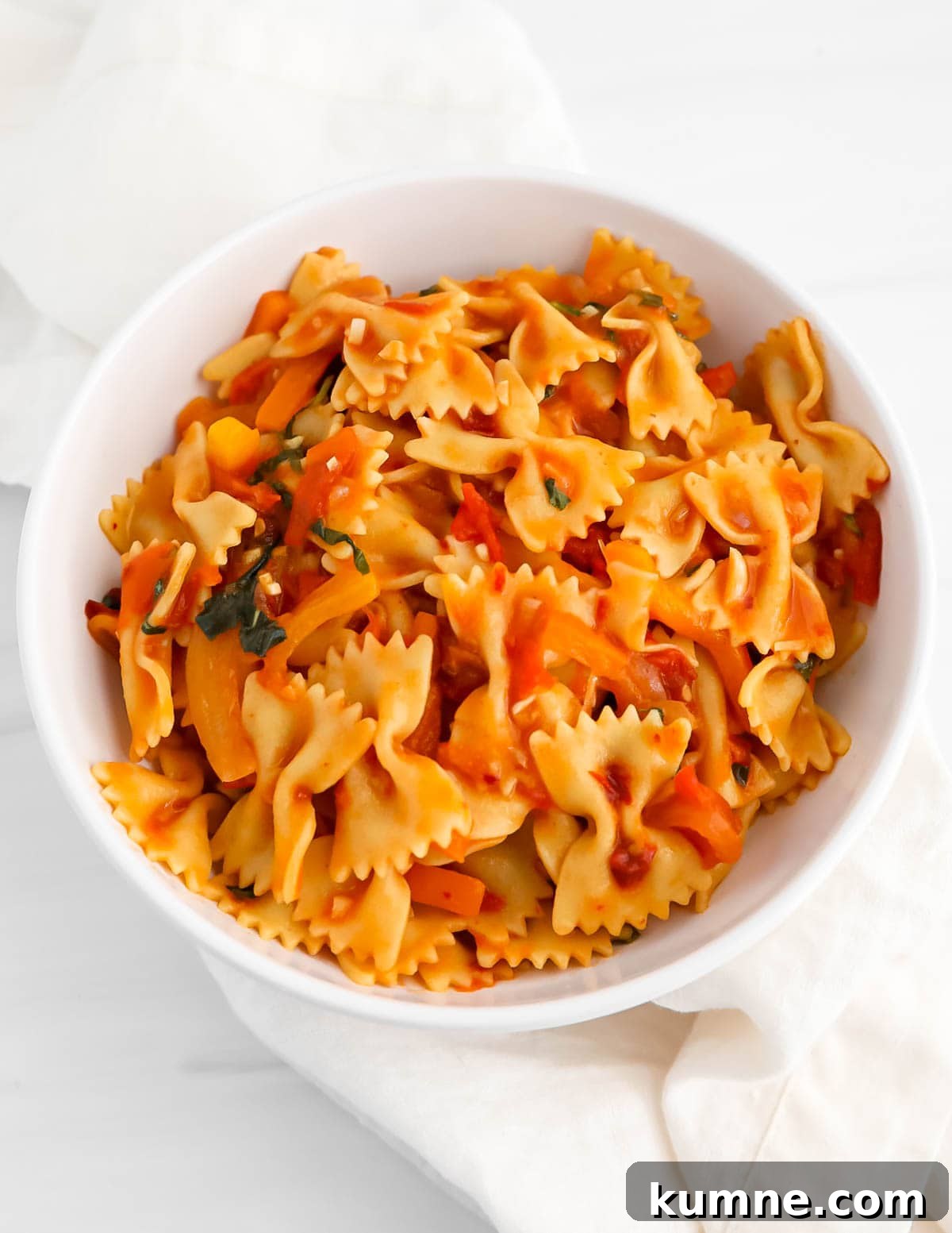 Pasta in a chunky red sauce in a white bowl.