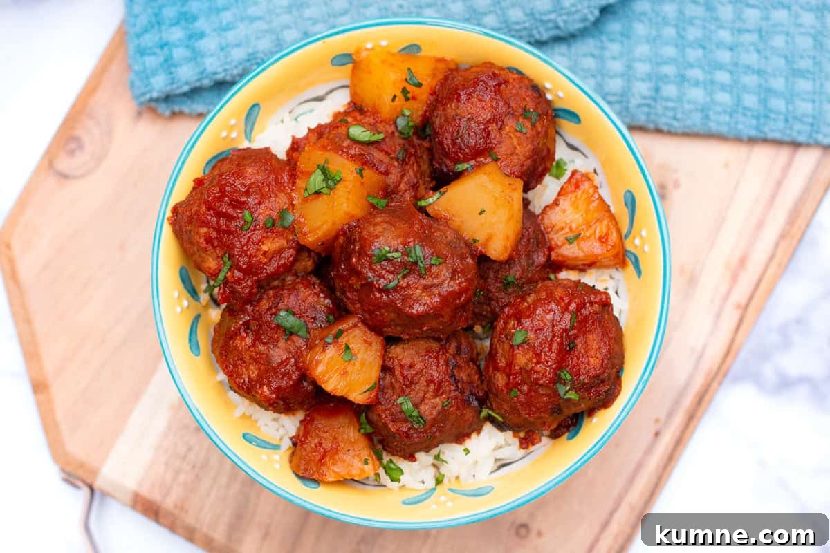 3-Ingredient Hawaiian Meatball Recipe with Pineapple Glaze 6 Top-down view of Hawaiian meatballs in a bowl over rice.