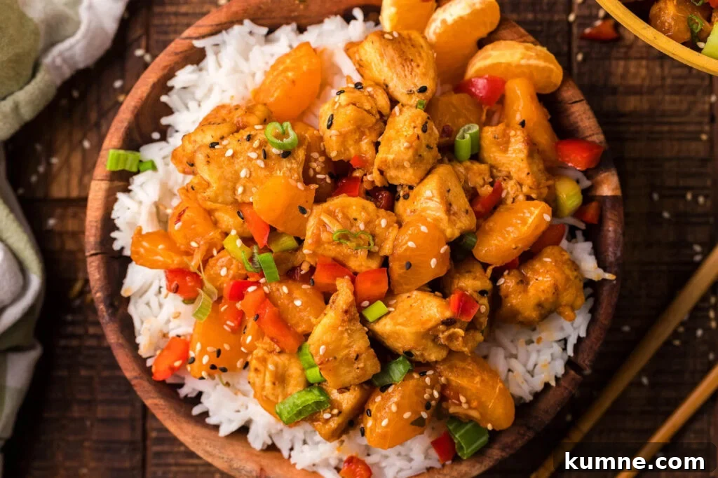 Tangerine chicken stir fry in a bowl with rice.