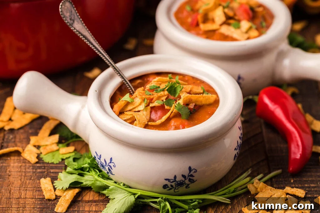 Homemade chicken enchilada soup in a white soup bowl with a handle.
