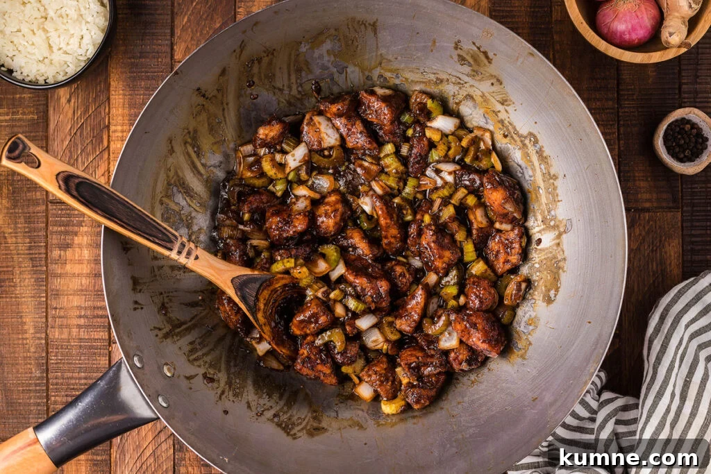 Stir frying black pepper chicken in a wok.