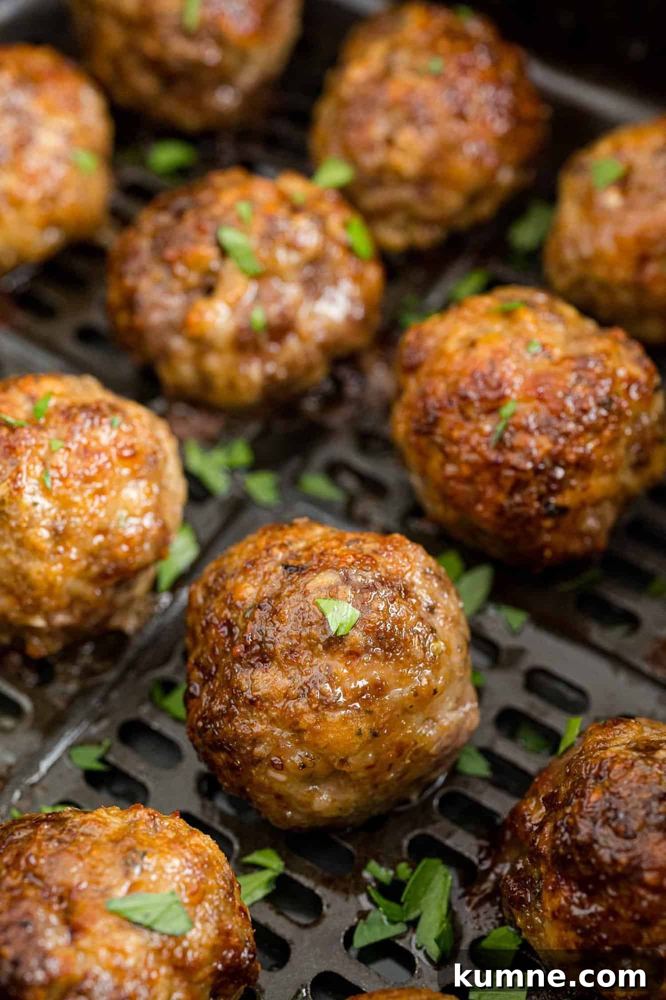 Crispy Air Fryer Italian-Style Meatballs Recipe 2 Meatballs in an air fryer basket.
