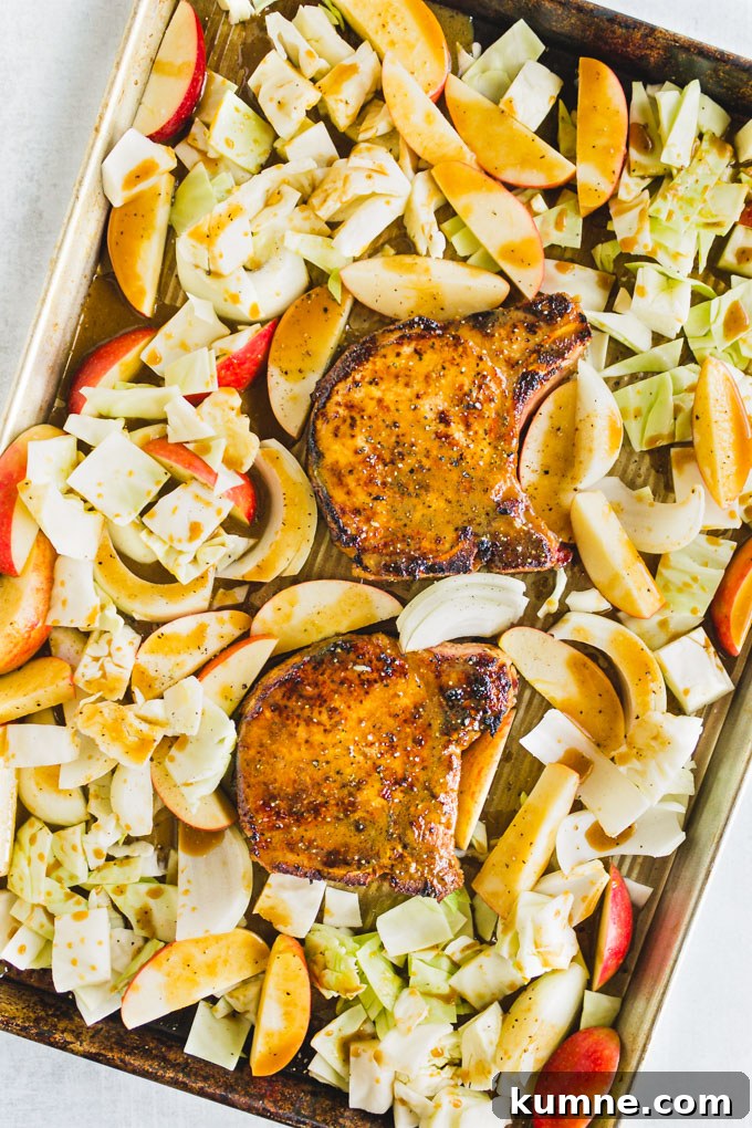 marinated pork with apples and cabbage on a sheet pan, before cooking.
