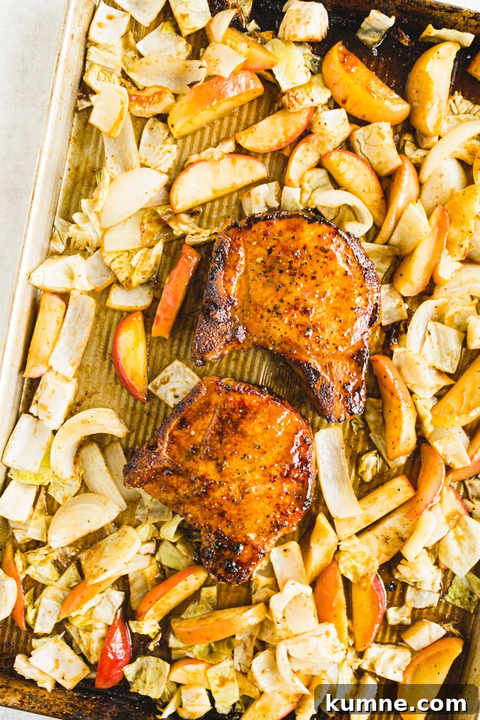marinated pork chops on a sheet pan with apples and cabbage.