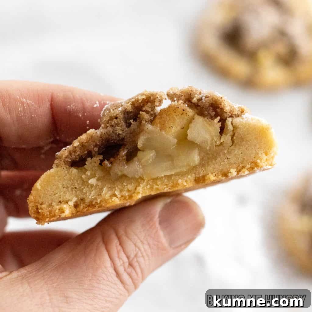 Apple Crumble Cookie Recipe — Soft Baked Fall Cookies, Step-by-Step 3 hand holding a cut apple pie cookie showing the inside