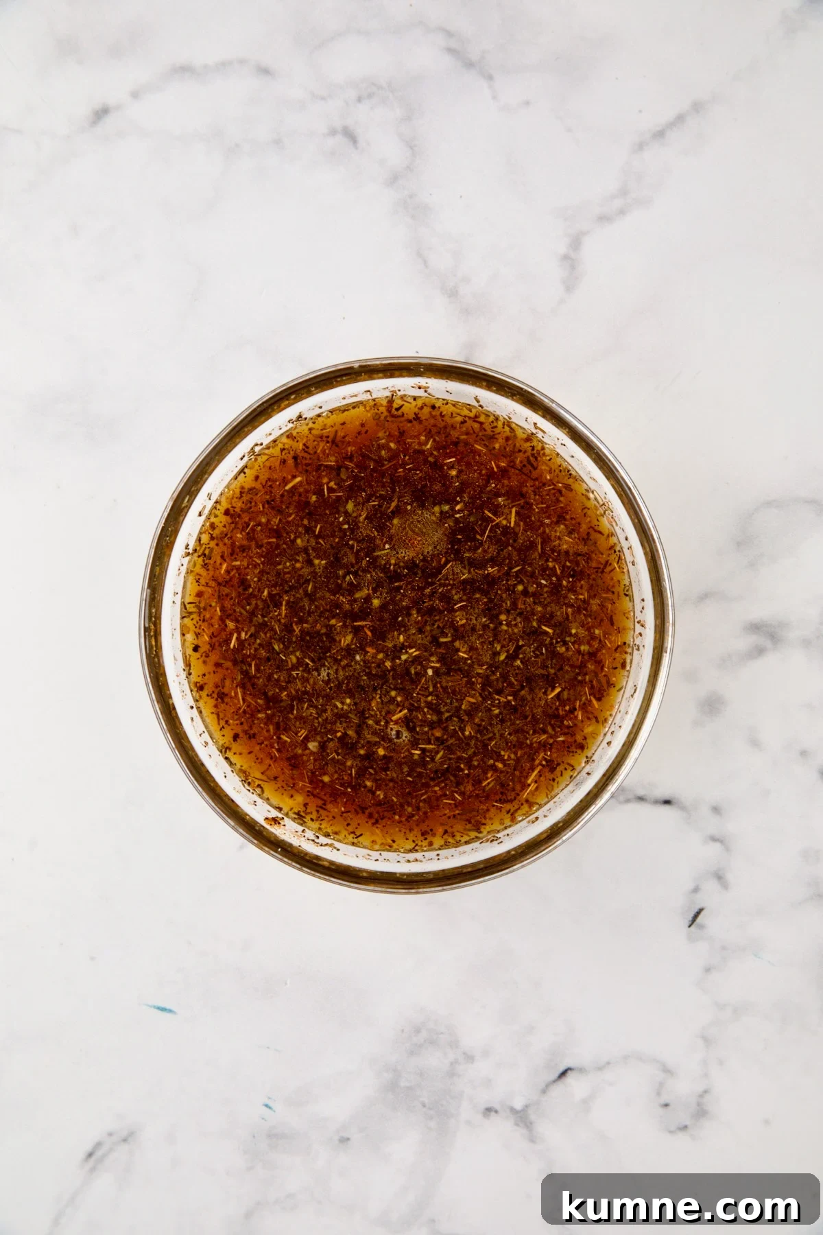 Herb and broth blend in glass bowl.