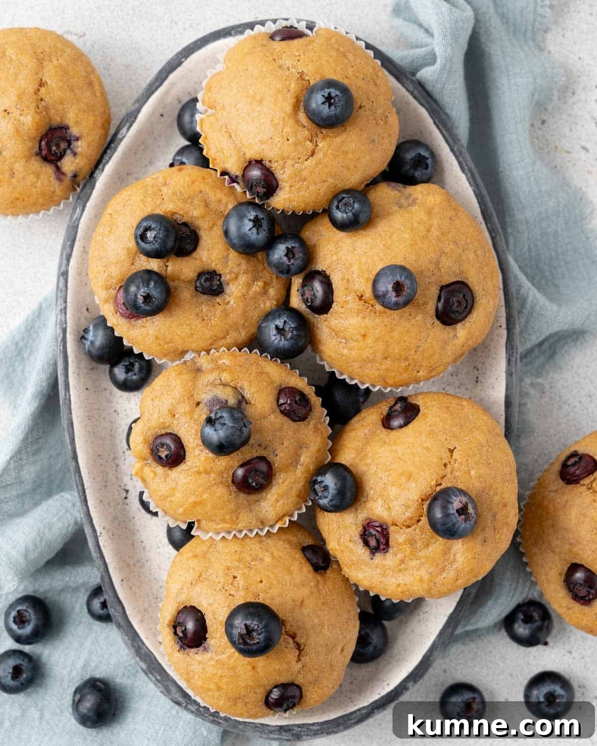 six muffins on a platter with blueberries.