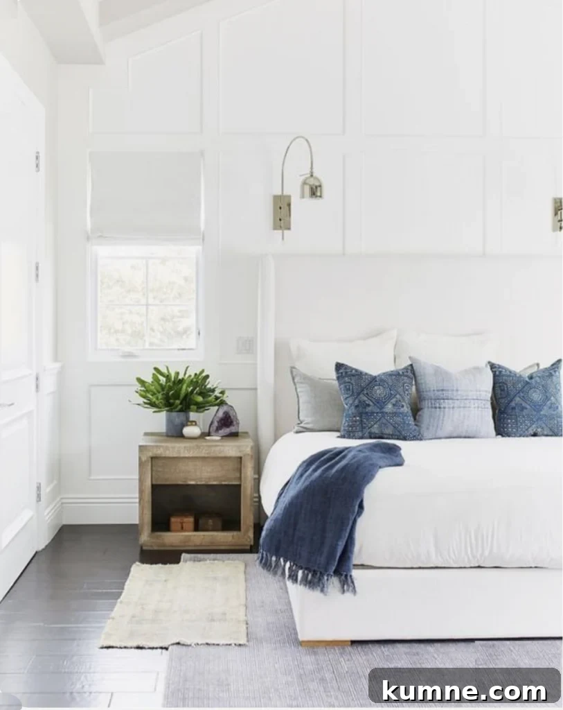 12 Gorgeous Board and Batten Bedroom Wall Ideas You’ll Love 14 a white bedroom with blue pillows and board and batten wall