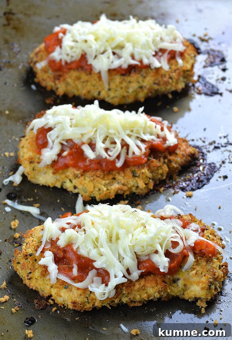 Three pieces of Baked Chicken Parmesan with marinara sauce on top, then sprinkle with shredded cheese