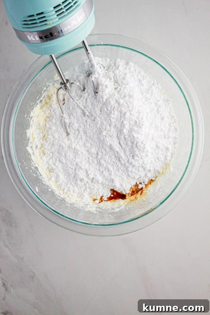 Butter, powdered sugar, and vanilla in a glass bowl.