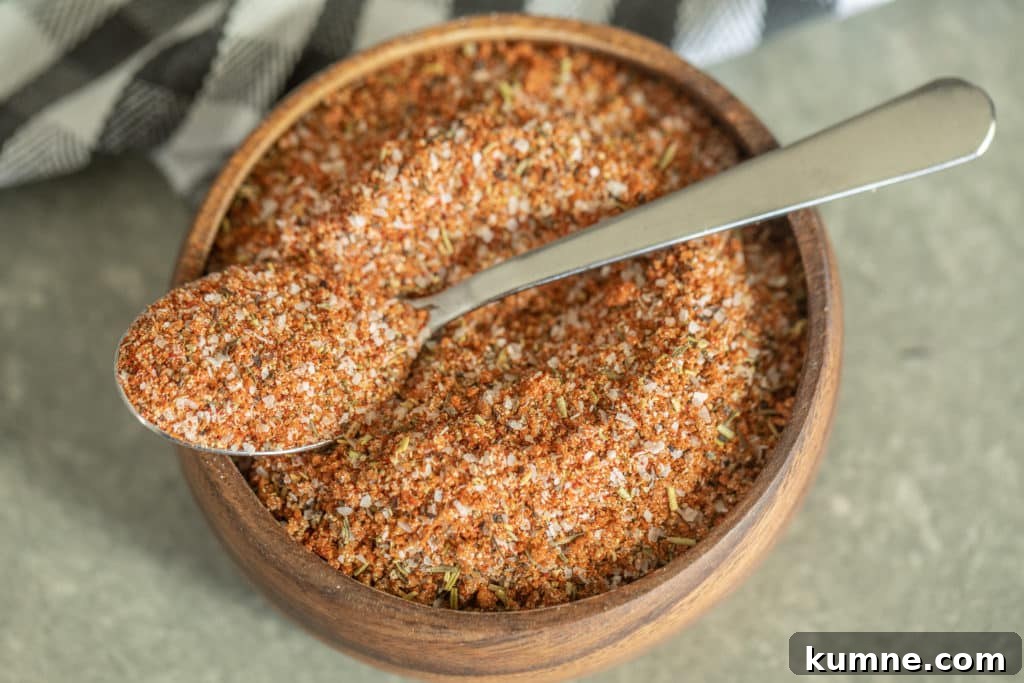 Smoked Turkey Rub Recipe Spoonful of smoked turkey rub over a wooden bowl of smoked turkey rub.