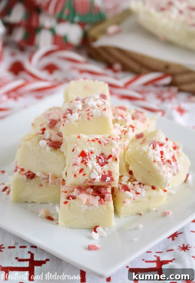 white chocolate peppermint fudge topped with peppermint candies on plate