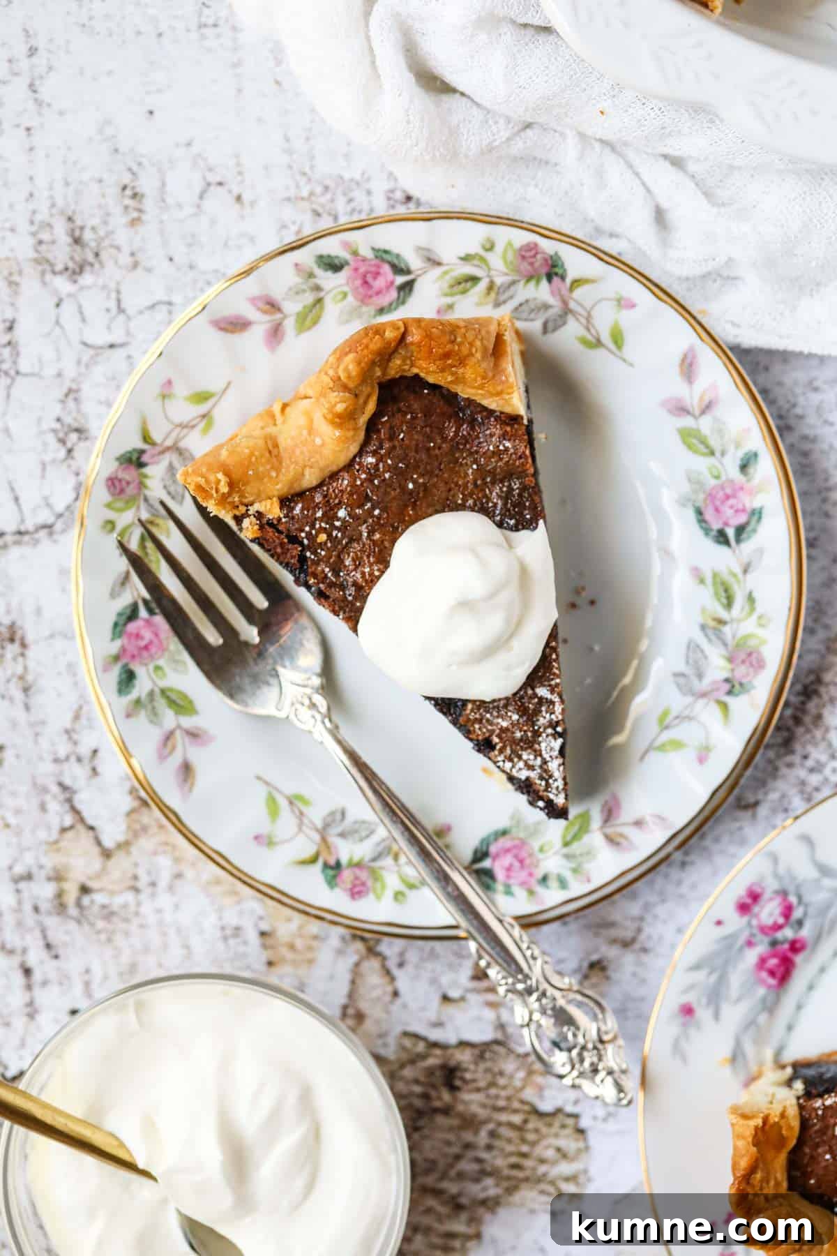 A slice of chocolate chess pie on a white dessert plate with a silver fork.