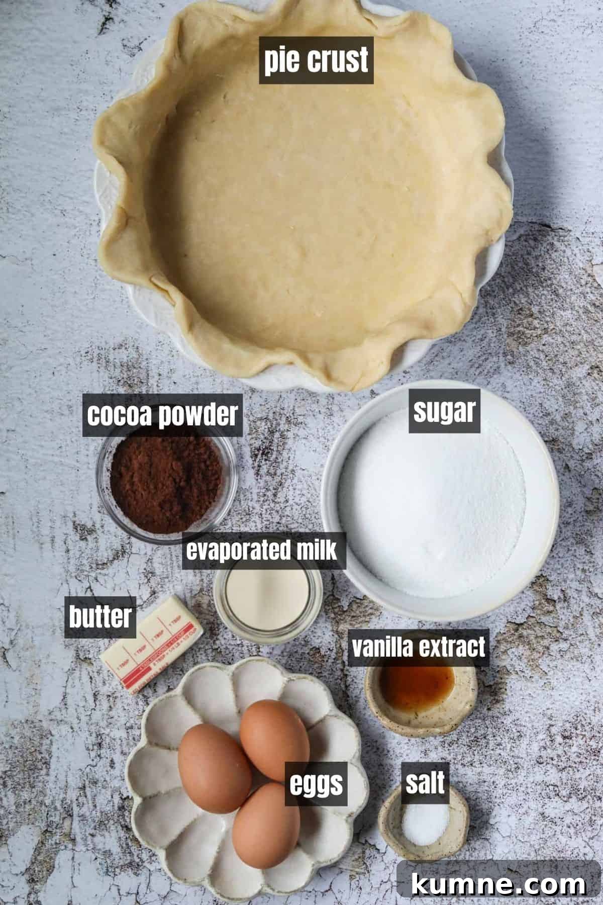 Ingredients for making chocolate chess pie arranged on a white surface.