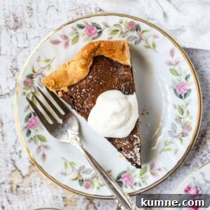 A slice of chocolate chess pie on a white dessert plate with a silver fork.