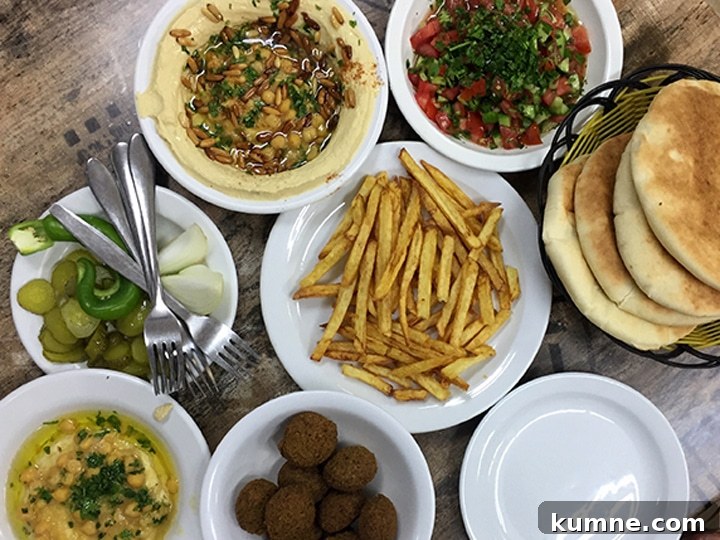 lunch spread of hummus, pickles, chopped salad, pita, falafel and french fries in the Muslim Quarter of the Old City of Jerusalem