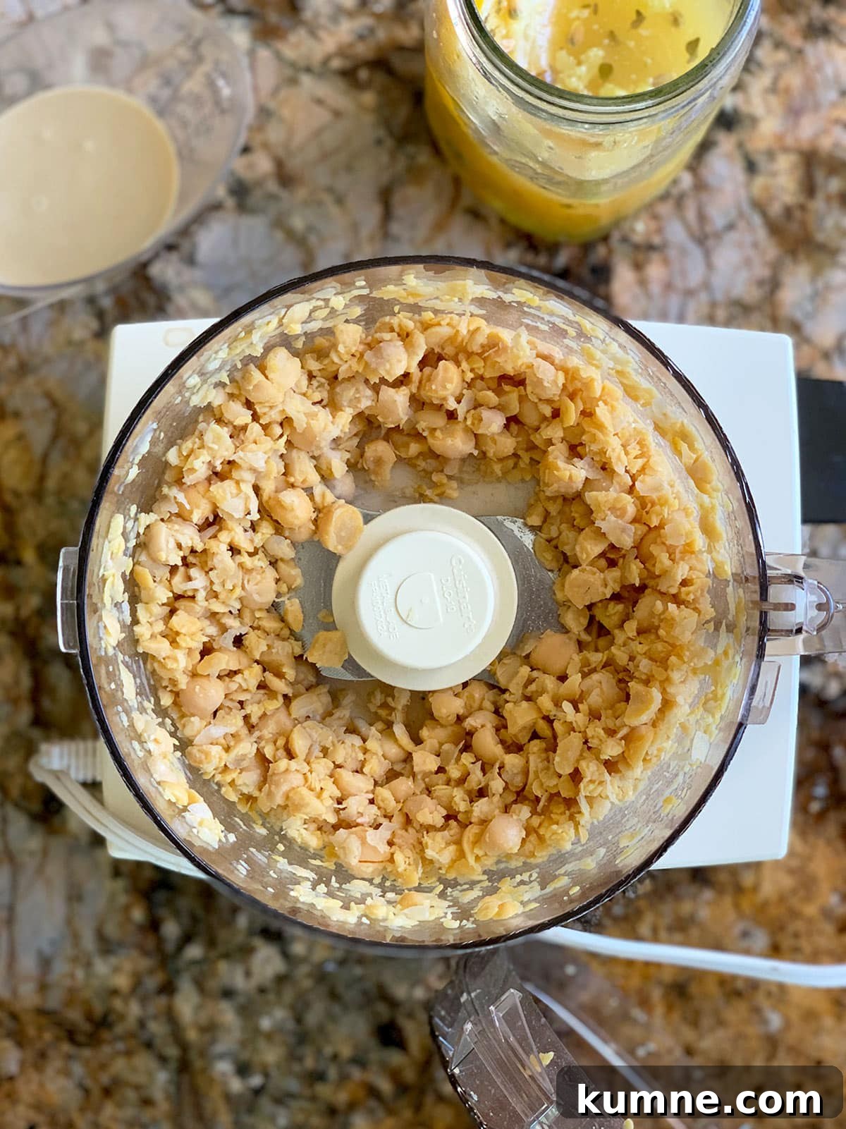 Chickpeas for preserved lemon hummus partially processed in food processor.