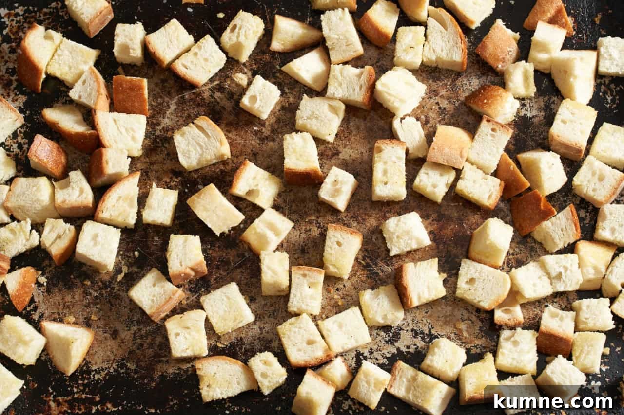 Cubed Italian bread on a sheet pan.