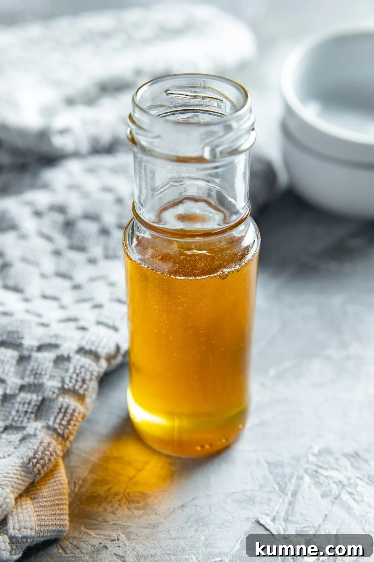 Honey in a tall slender glass container.