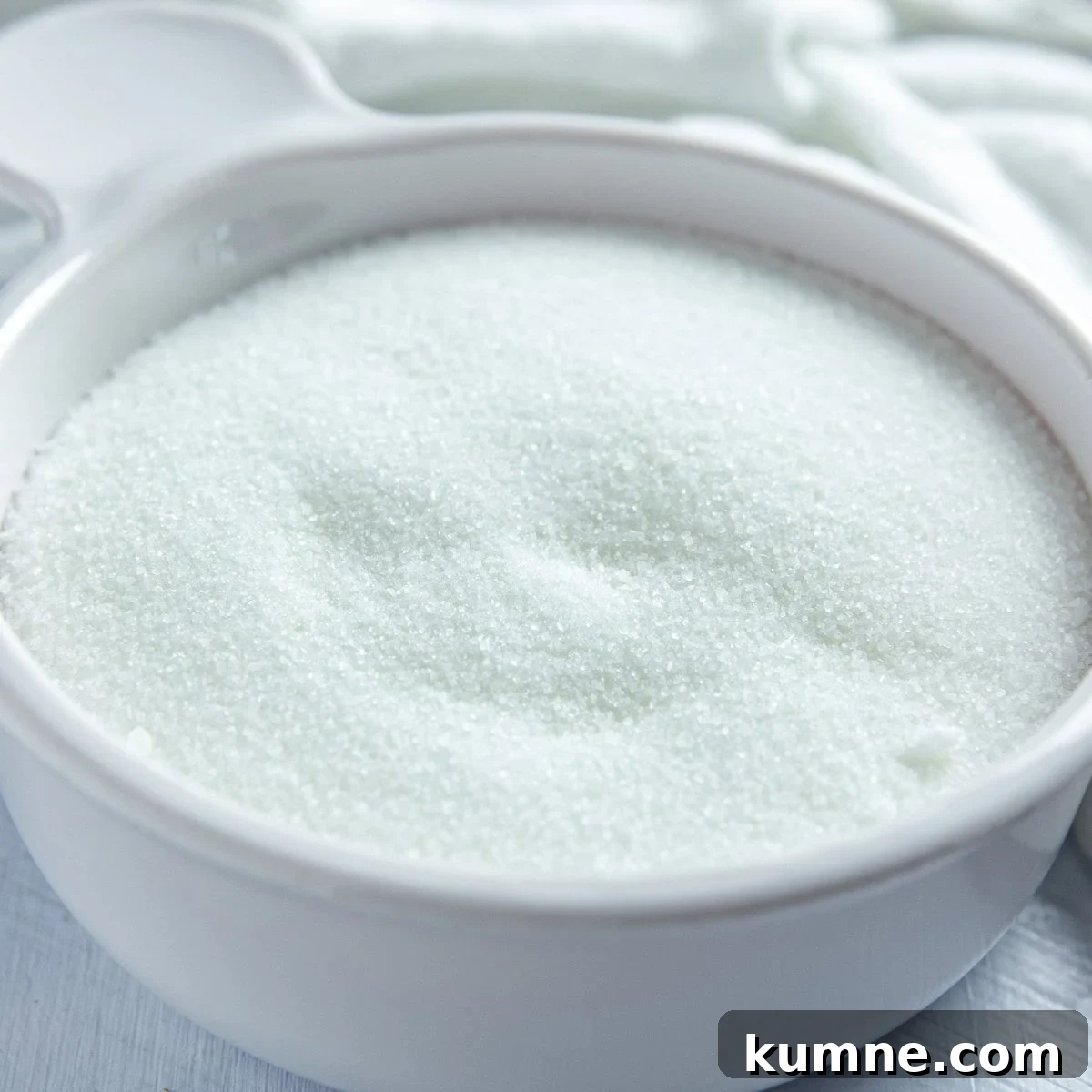Granulated sugar in a white bowl.