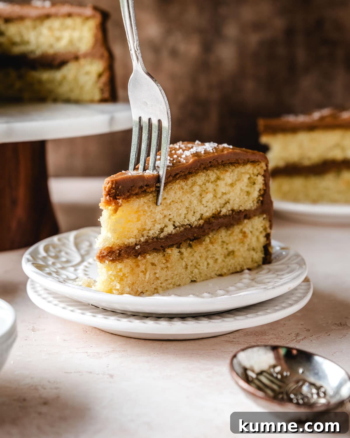 Sticking a fork into a slice of salted caramel cake.