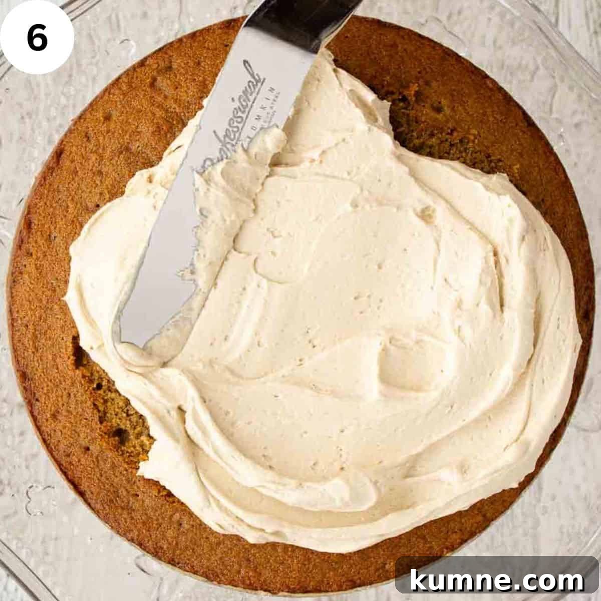 Buttercream being spread on a cake with a palette knife.