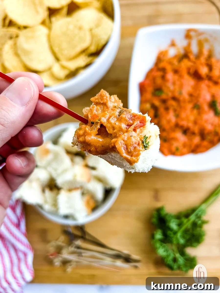 Large cube of bread on a toothpick, covered in smoked queso with chorizo.