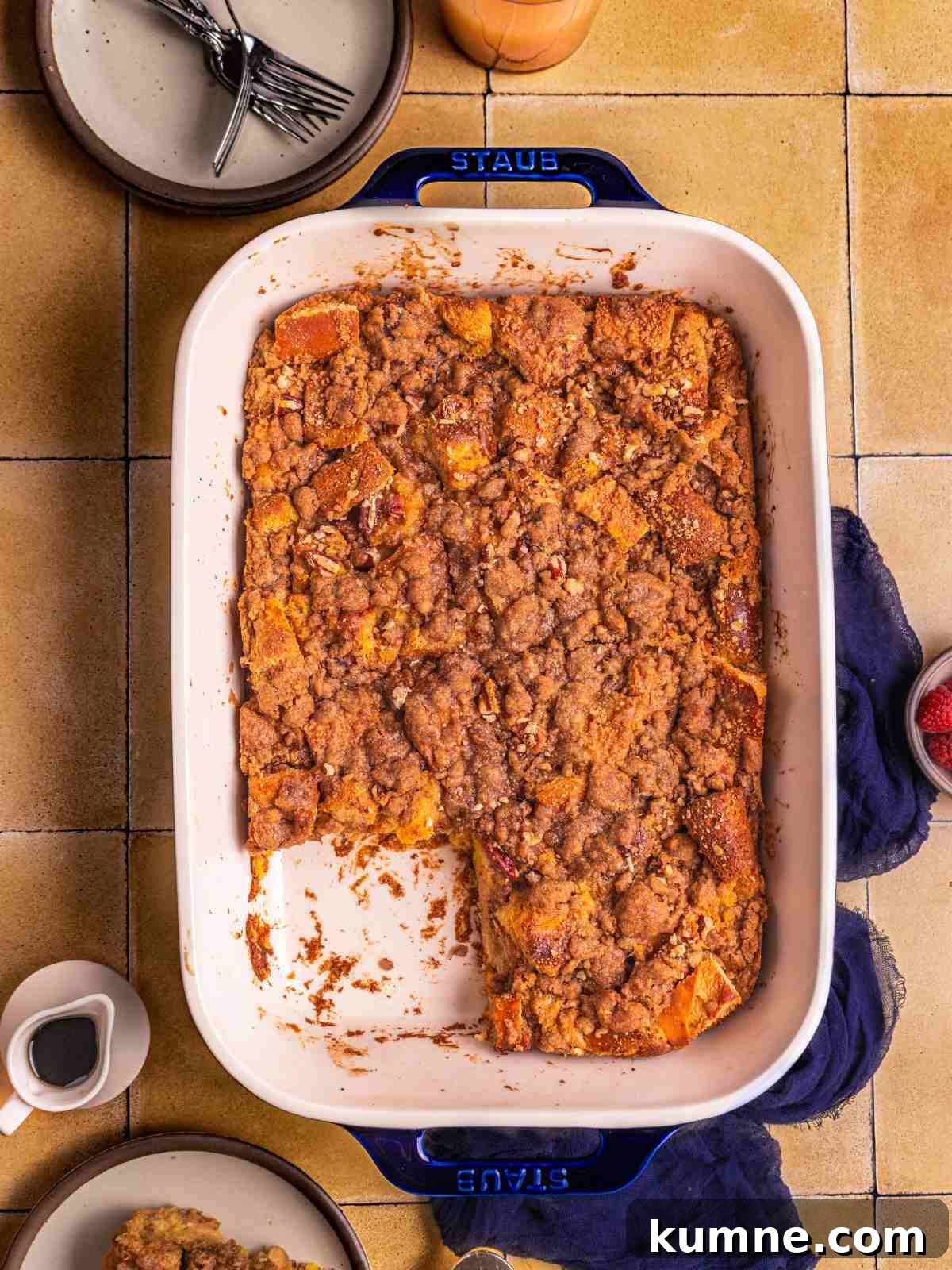 A baked French toast casserole with serving plates and fork.